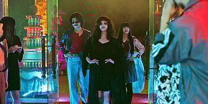 A still from the film DEAD TALENTS SOCIETY with three ghosts standing in a doorway with their hands on their hips