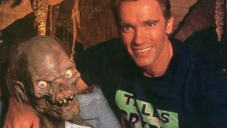 Arnold Schwarzenegger hugs the Crypt Keeper in Tales from the Crypt.