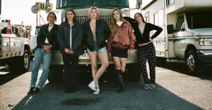 A motley group of women stand in front of a semi truck in this photograph from CANDY LAND.