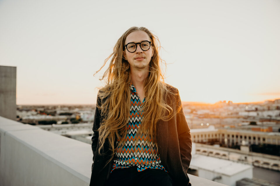 Missing composer Julian Scherle standing on a building rooftop. 