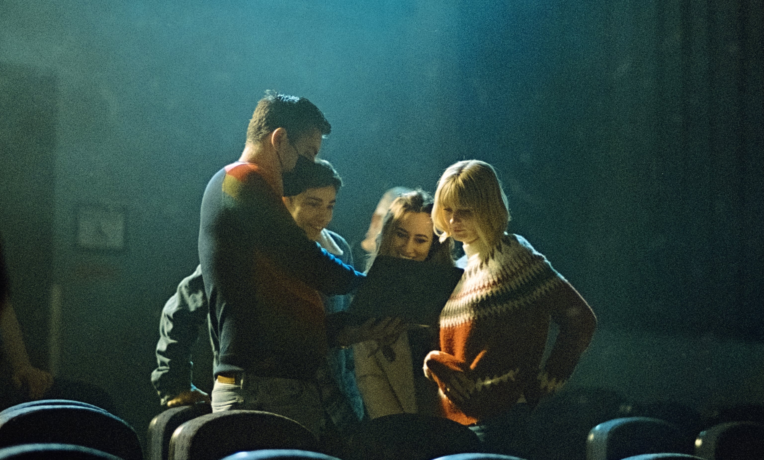 Actors Jess McCleod and Jane Widdop look at a script with two crew members on the set of "It's a Wonderful Knife"